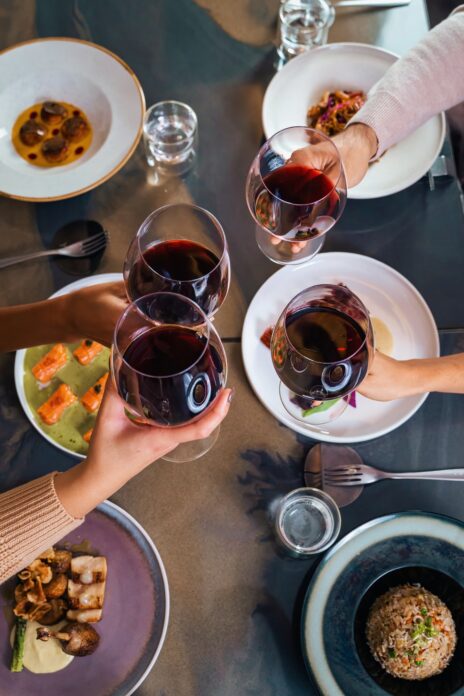 Friends dining restaurant wine tasting celebration social gathering gourmet food sharing plates